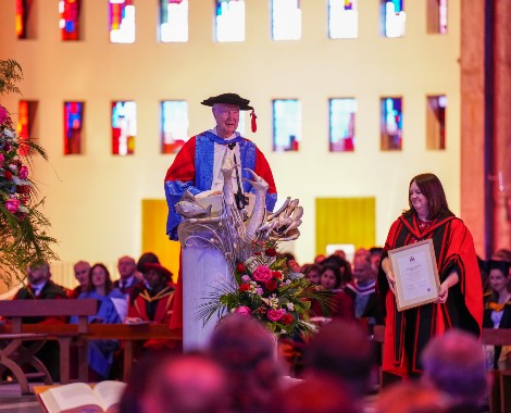 Fr Timothy Radcliffe delivers a speech from a lectern at Liverpool Metropolitan Cathedral wearing his honorary doctorate cap and gown.